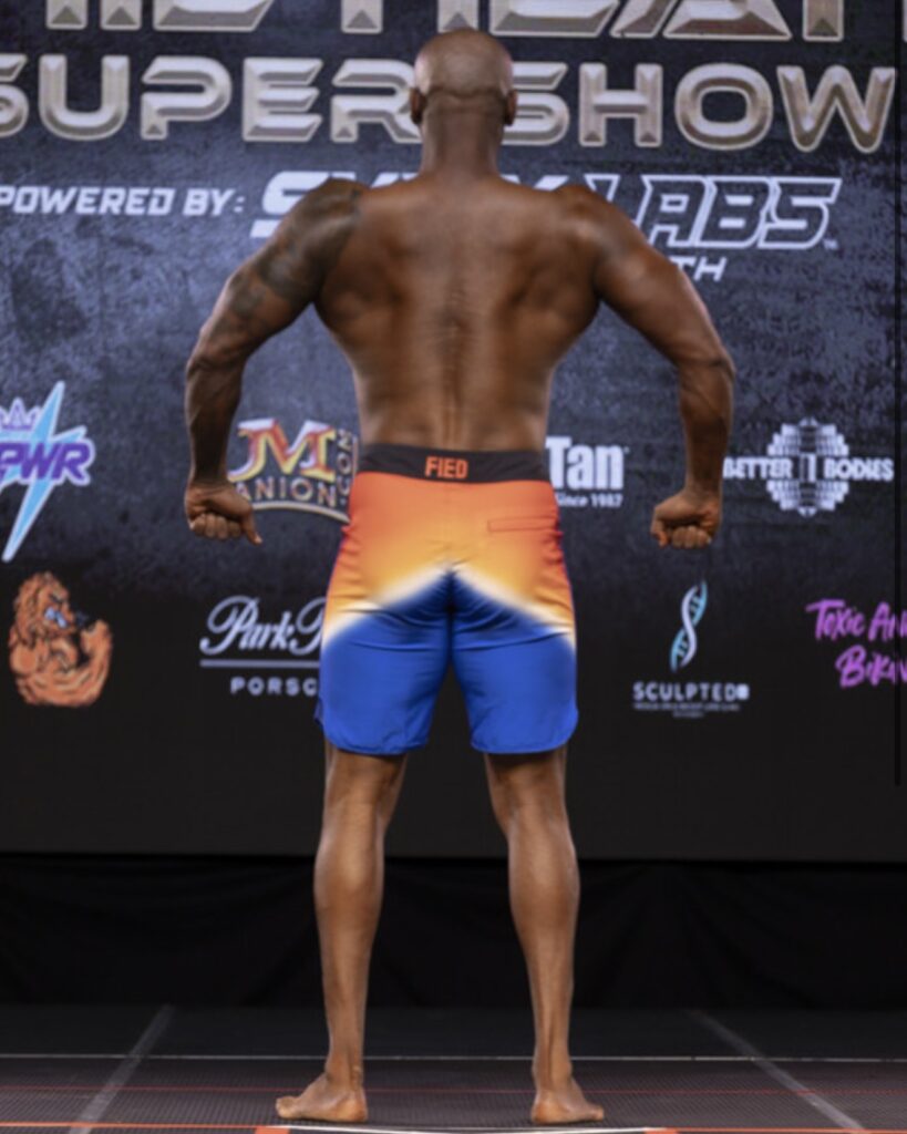 Male bodybuilder poses on stage