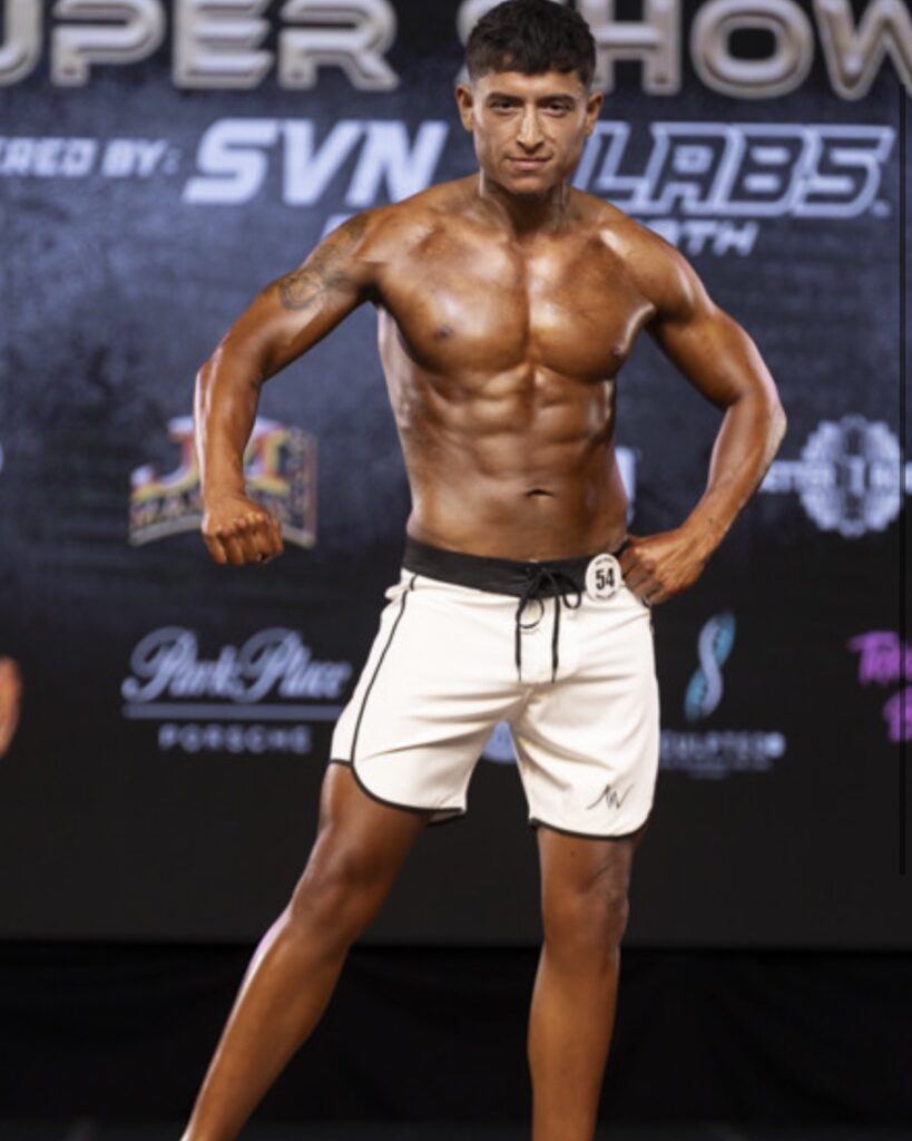 Male bodybuilder poses on stage